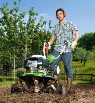 Imagen que muestra a una persona arando en su terreno con una motoazada de huerto.